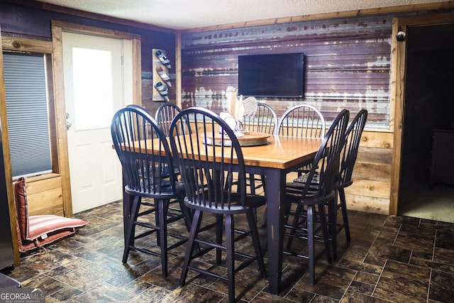 5524 Hooker Branch Rd, Millen, GA 30442 - dining area featuring wood walls, stone finish flooring, and a textured ceiling