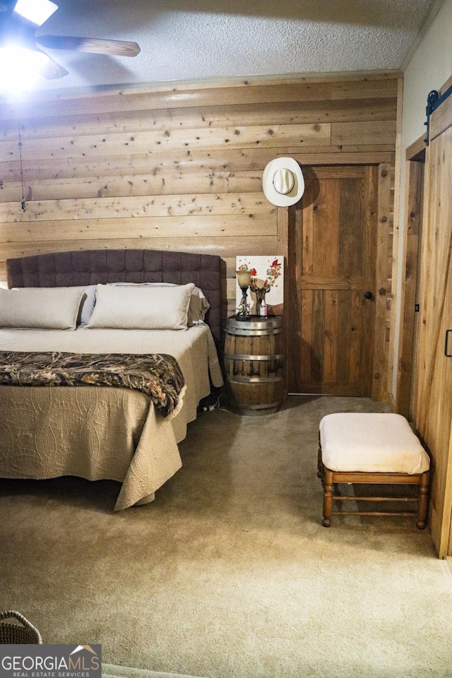 5524 Hooker Branch Rd, Millen, GA 30442 - carpeted bedroom with wooden walls, a barn door, and a textured ceiling