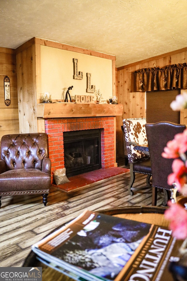5524 Hooker Branch Rd, Millen, GA 30442 - living area featuring wooden walls, a textured ceiling, wood finished floors, and a fireplace