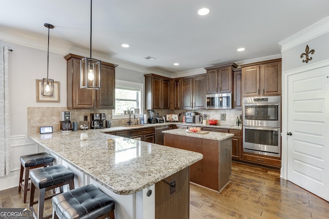 3097 Trinity Grove Dr, Dacula, GA 30019 - kitchen with a sink, appliances with stainless steel finishes, a kitchen island, light stone countertops, and a peninsula