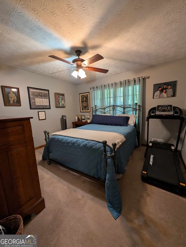 bedroom with a ceiling fan, a textured ceiling, light colored carpet, and baseboards