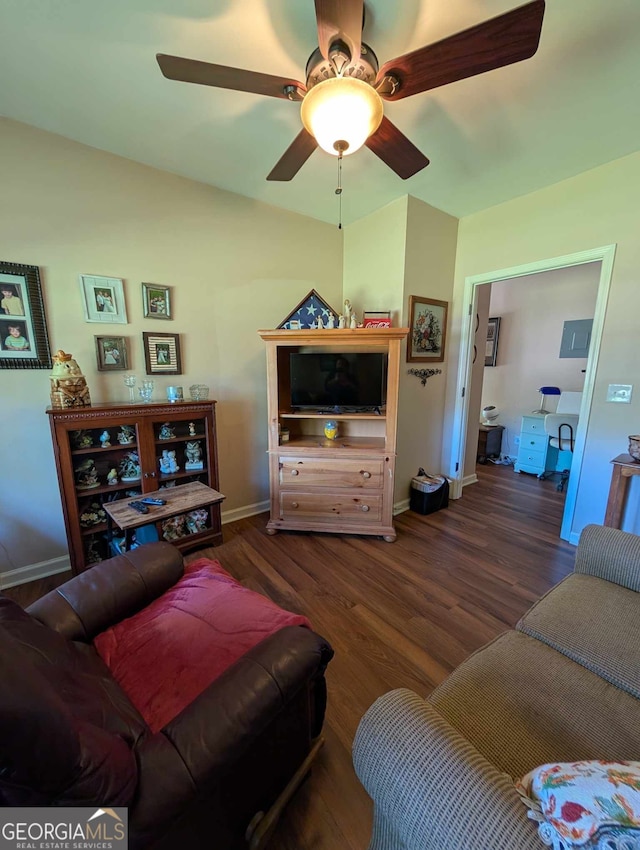 living room with baseboards, a ceiling fan, and dark wood finished floors