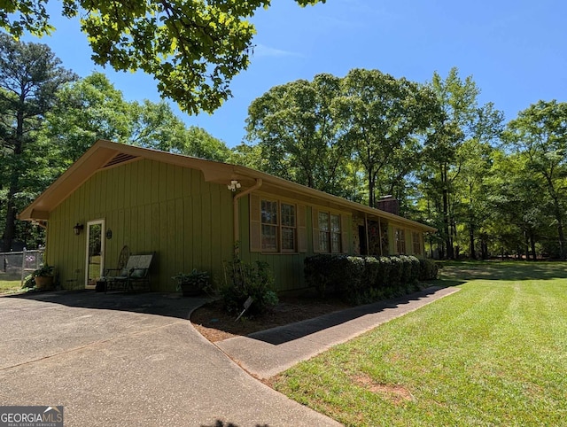 view of side of home featuring a yard and a chimney