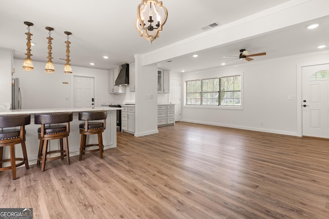 705 Oak Ln, Brunswick, GA 31523 - kitchen with custom exhaust hood, a kitchen breakfast bar, light wood finished floors, recessed lighting, and a ceiling fan