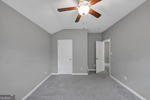 unfurnished bedroom with a ceiling fan, baseboards, lofted ceiling, and carpet flooring
