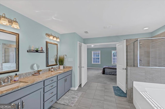 bathroom featuring double vanity, visible vents, a stall shower, and a sink