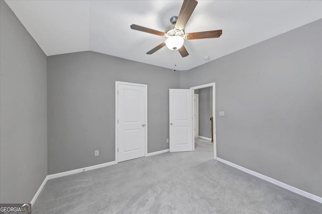 unfurnished bedroom featuring vaulted ceiling, baseboards, carpet floors, and ceiling fan