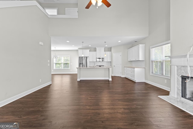 517 Lago Ct, Lagrange, GA 30241 - unfurnished living room featuring dark wood finished floors, a high end fireplace, a ceiling fan, and a towering ceiling