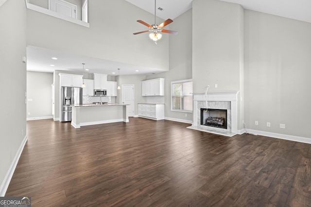 517 Lago Ct, Lagrange, GA 30241 - unfurnished living room featuring ceiling fan, baseboards, dark wood-type flooring, and a fireplace