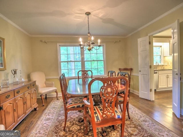 dining area with crown molding, dark wood-style flooring, baseboards, and a notable chandelier