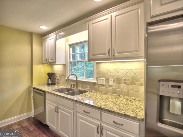 kitchen featuring decorative backsplash, baseboards, dark wood-type flooring, a sink, and stainless steel appliances