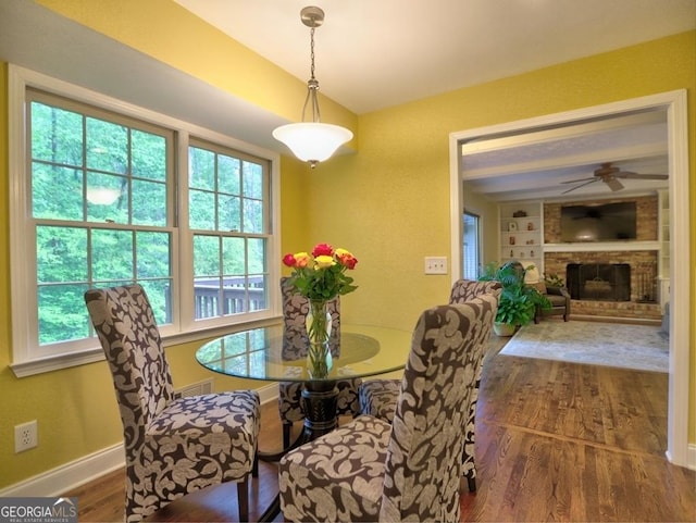 dining room with a healthy amount of sunlight, ceiling fan, wood finished floors, and visible vents