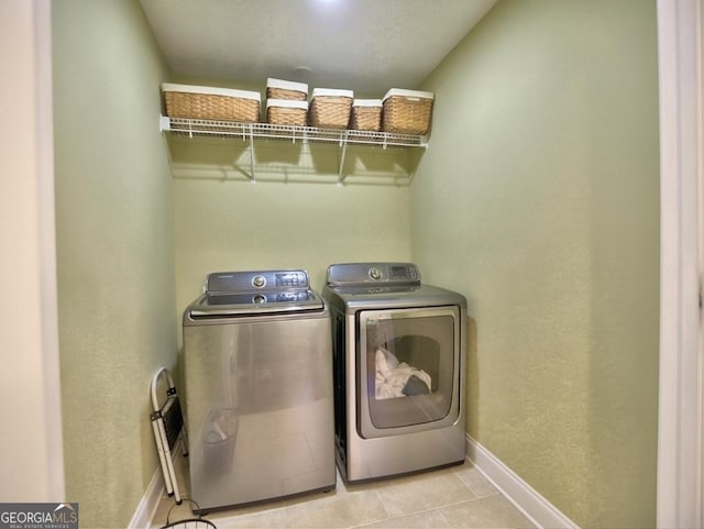 laundry room featuring light tile patterned floors, baseboards, laundry area, and washer and clothes dryer