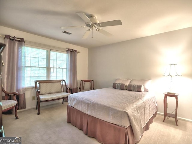 bedroom with baseboards, ceiling fan, light colored carpet, and visible vents