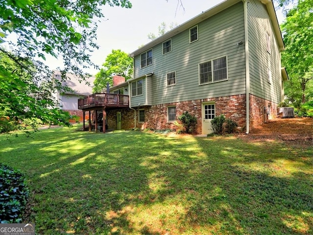 rear view of property featuring a deck, brick siding, central air condition unit, a yard, and stairway