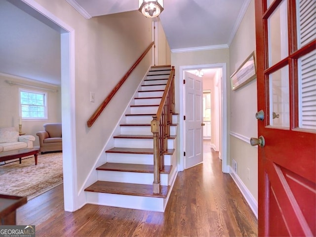 foyer featuring stairs, crown molding, visible vents, and wood finished floors