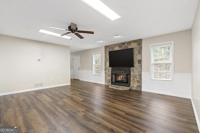 499 Old Deer Path Way, Cleveland, GA 30528 - unfurnished living room featuring dark wood-type flooring, visible vents, a wainscoted wall, and a stone fireplace