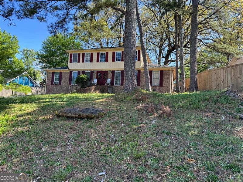 view of front of home featuring fence and brick siding