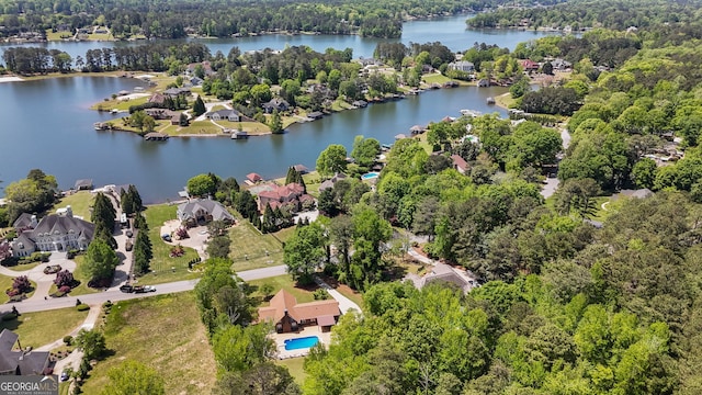 drone / aerial view with a water view, a residential view, and a wooded view