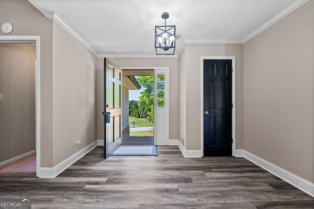foyer with an inviting chandelier, wood finished floors, crown molding, baseboards, and a textured ceiling