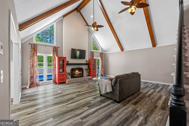 living area with wood finished floors, beam ceiling, baseboards, high vaulted ceiling, and ceiling fan