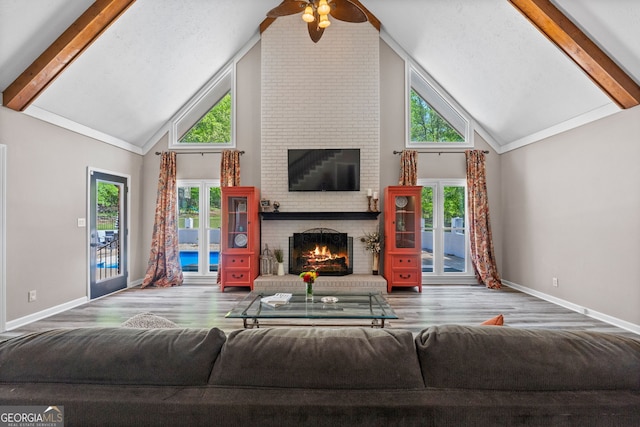 living area with high vaulted ceiling, beam ceiling, wood finished floors, and a fireplace
