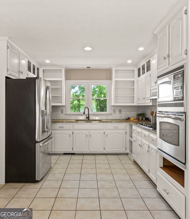 kitchen featuring open shelves, white cabinets, a sink, and appliances with stainless steel finishes