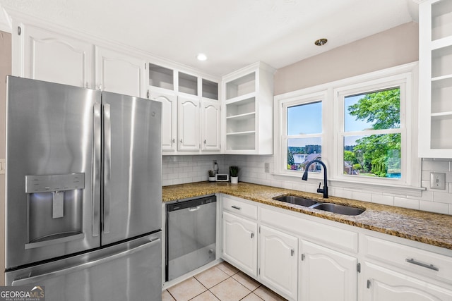 kitchen featuring white cabinets, open shelves, stone countertops, a sink, and appliances with stainless steel finishes