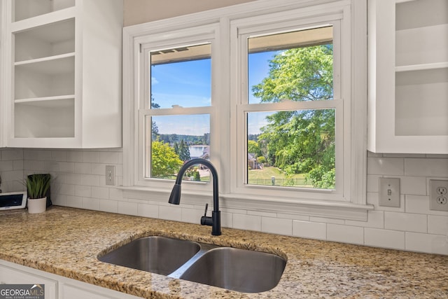 kitchen with white cabinets, glass insert cabinets, decorative backsplash, and a sink