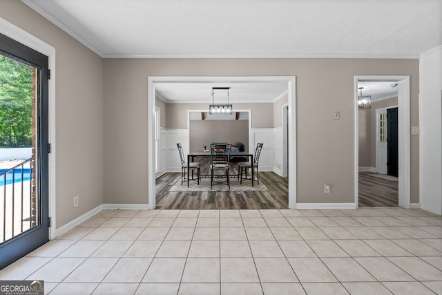 dining room featuring a chandelier, light wood-style floors, crown molding, and baseboards