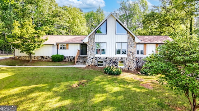view of front of property with stone siding and a front yard