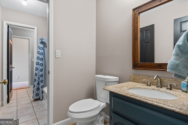 bathroom featuring baseboards, vanity, and toilet