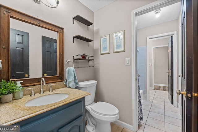 full bathroom featuring baseboards, vanity, tile patterned flooring, and toilet