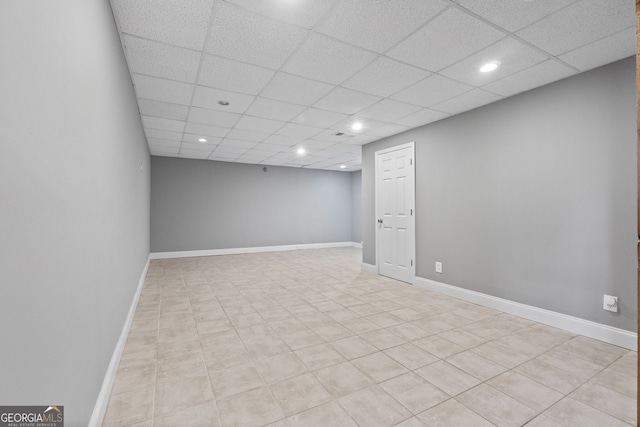finished below grade area with light tile patterned floors, baseboards, a paneled ceiling, and recessed lighting