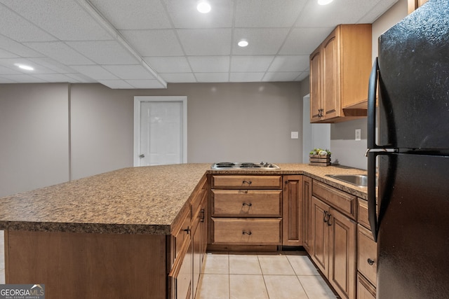 kitchen with cooktop, light tile patterned floors, freestanding refrigerator, a peninsula, and recessed lighting