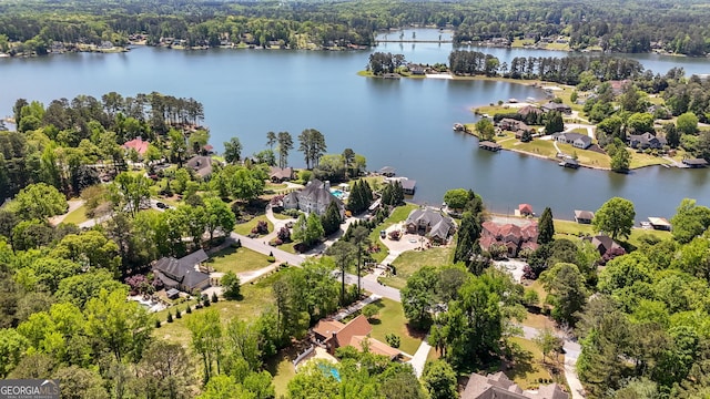 drone / aerial view with a residential view, a forest view, and a water view