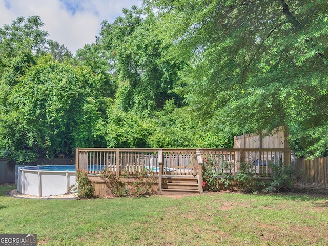 view of yard with a deck and an outdoor pool