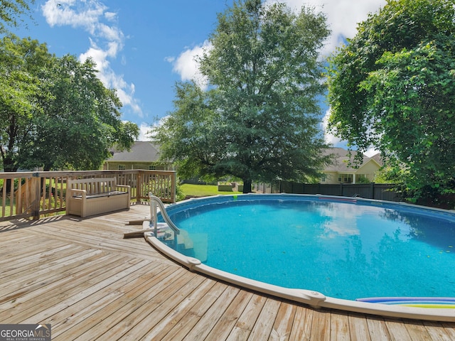 view of pool featuring a deck and fence