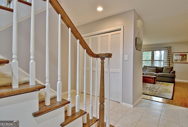 staircase featuring baseboards, tile patterned floors, and recessed lighting