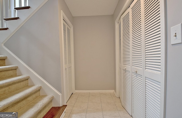 hallway featuring stairway and baseboards