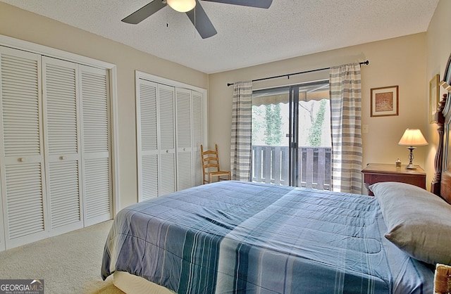 carpeted bedroom featuring a ceiling fan, access to outside, a textured ceiling, and two closets