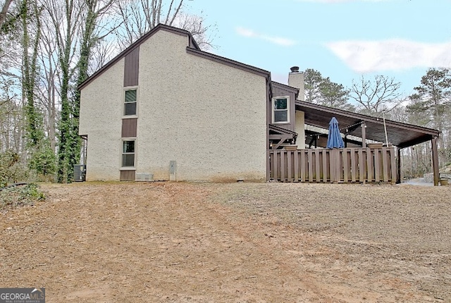 view of property exterior with a chimney and stucco siding
