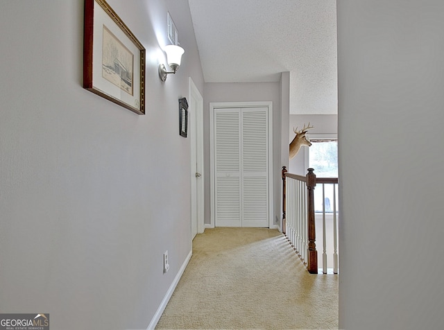 hall featuring visible vents, baseboards, light carpet, and an upstairs landing
