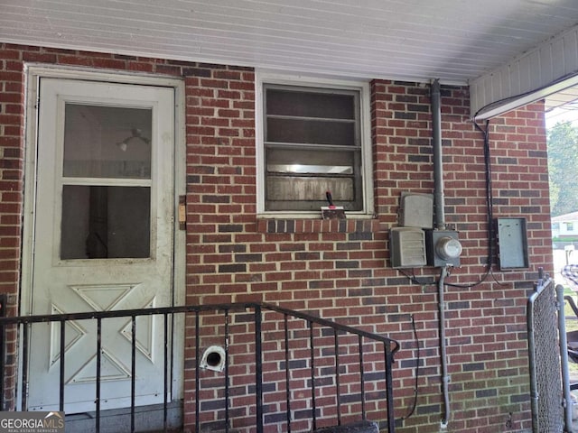 details featuring electric meter and brick siding