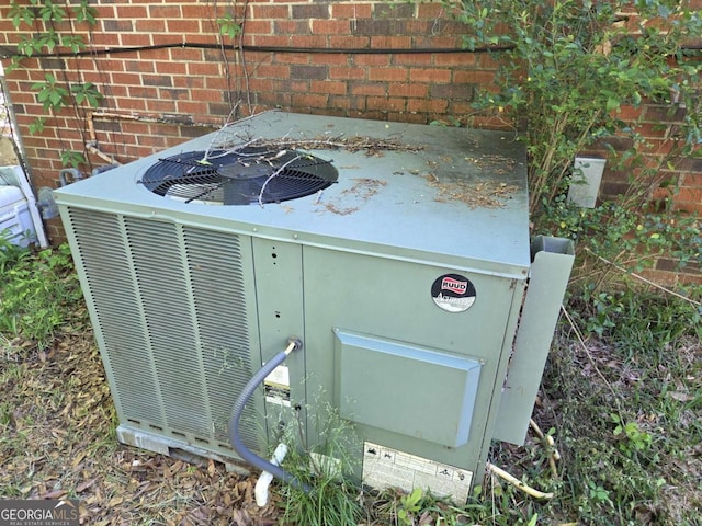 details featuring cooling unit and brick siding