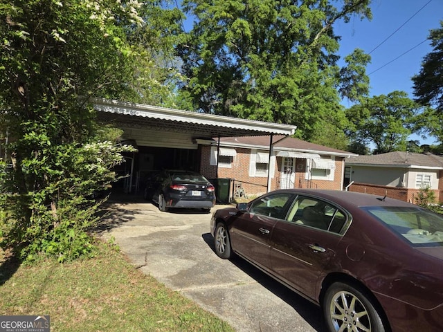 exterior space with brick siding, driveway, and an attached carport