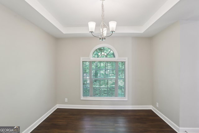 1945 Grayson Oaks Ct, Lawrenceville, GA 30045 - unfurnished room featuring an inviting chandelier, a raised ceiling, and wood finished floors