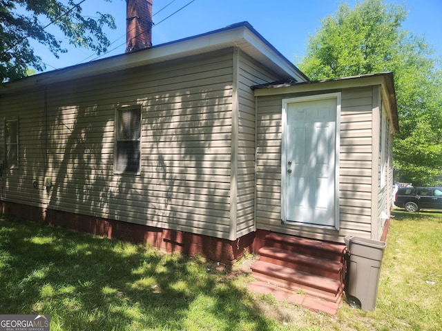 4 Maple St, Porterdale, GA 30014 - view of property exterior with a lawn, a chimney, entry steps, and crawl space