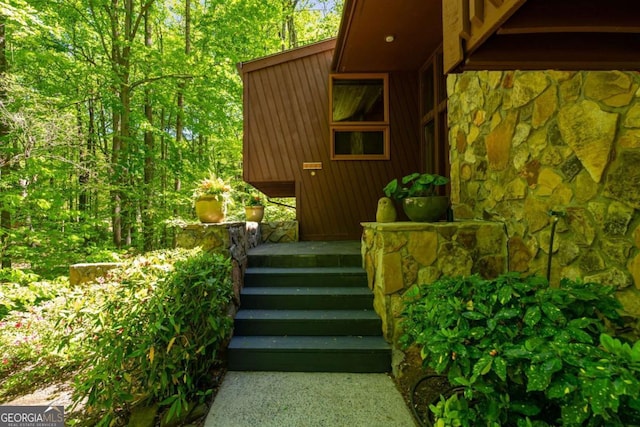 exterior space featuring stone siding and metal roof