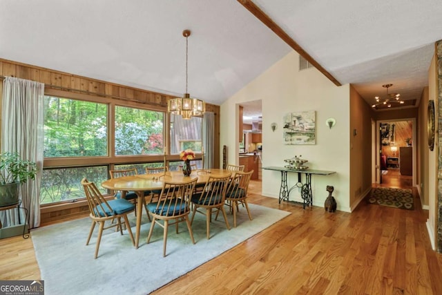 dining area featuring lofted ceiling, light wood-style flooring, baseboards, and a chandelier